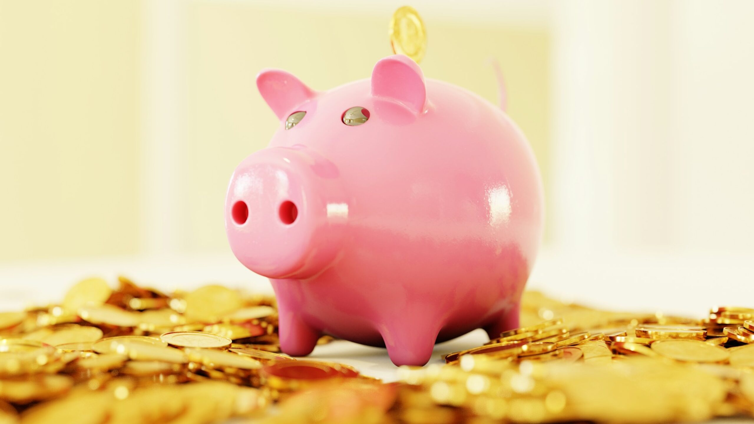 ein rosa Sparschwein auf einem Teppich von Münzen